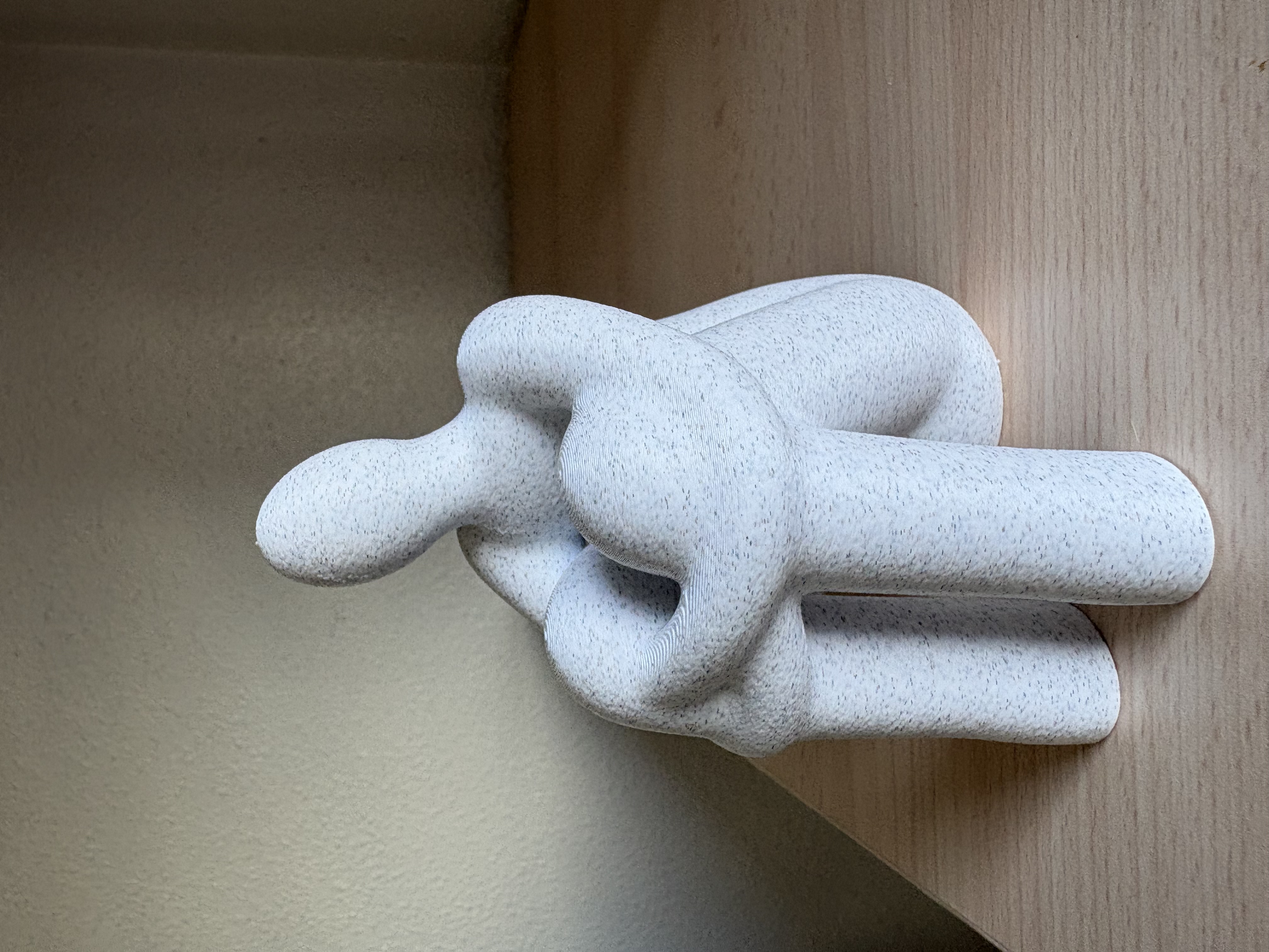 Calma impresa con acabado blanco moteado, fotografiada sobre madera
